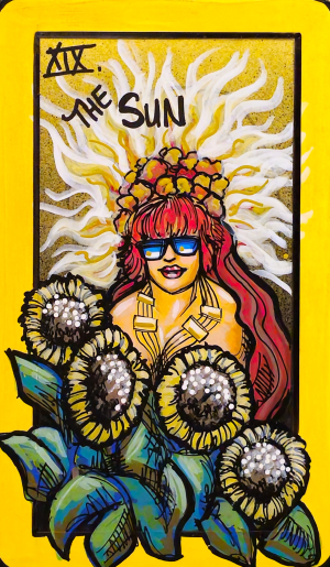A tarot painting of The Sun. A smiling figure with long red hair wears reflective sunglasses, a crown of yellow blossoms, and chunky gold jewelry. Radiant white-and-gold sun rays flare outward behind them, creating a bright halo. In the foreground, large sunflowers with textured glittering centers face outward, surrounded by bold green leaves. The border is golden yellow, with text at the top reading “XIX The Sun.” The image conveys joy, radiance, and celebration.